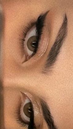 a woman's eye with long lashes and brown eyes