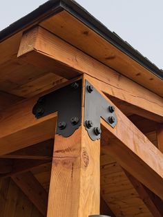 the top of a wooden structure with metal brackets on it's sides and roof