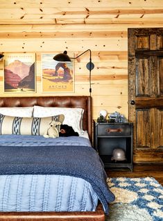 a bed in a bedroom with wood paneling and pictures on the wall above it