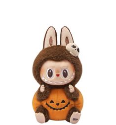 a stuffed animal with a pumpkin on it's chest and eyes closed, sitting in front of a white background