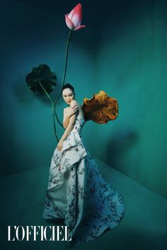 a woman is holding a flower in her hand and posing for the cover of officiel magazine