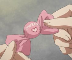 two hands holding a pink bow with the word sweet on it