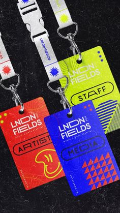 three lanyards with different colored tags attached to them on a black table top