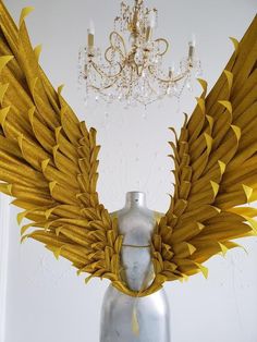 an artistic display with gold wings and a chandelier