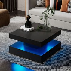 a living room with couch, coffee table and blue lights on the bottom part of it