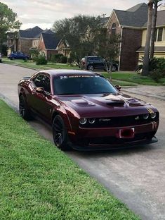 a red sports car parked on the side of a road next to a street sign