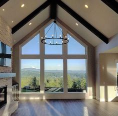 a living room with large windows and a chandelier