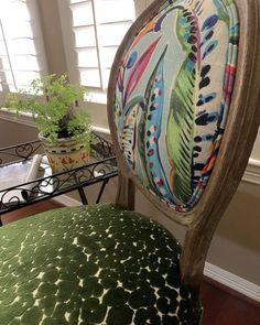 the back of a chair with an upholstered seat and colorful fabric on it