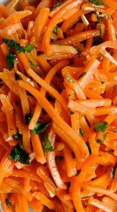 a white bowl filled with shredded carrots and parsley