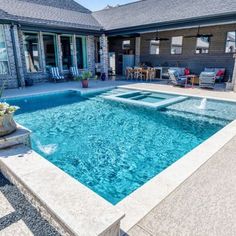 an empty swimming pool in front of a house