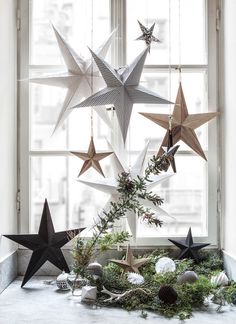 a window sill with christmas decorations hanging from it's sides and stars on the windowsill