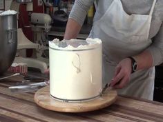 a chef is decorating a cake with icing