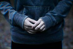 a person with their hands in the pocket of a hoodie sweatshirt that is open