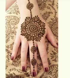 a woman's hand with henna tattoos on it