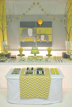 a yellow and white dessert table with cupcakes, cake and candy bars on it