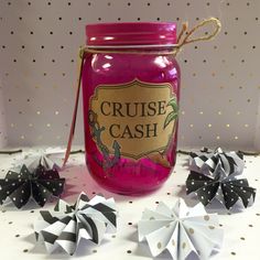 a pink jar with some black and white pinwheels next to it