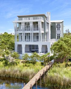 an artist's rendering of a two story house on stilts next to a body of water