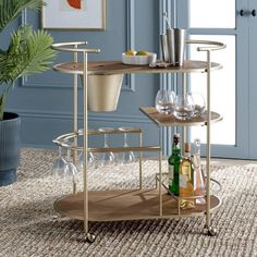 a bar cart with wine glasses and bottles on it