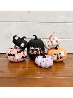 a group of pumpkins with happy halloween written on them sitting on a wooden table