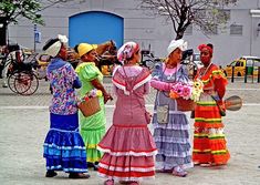 four women in colorful dresses are talking to each other