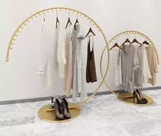 there are two circular mirrors with clothes hanging on the rack and one has high heels