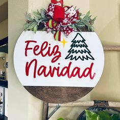 a sign that says feliz navidada hanging on the wall next to a potted plant