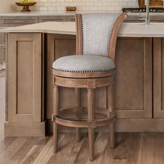 a kitchen with an island and bar stools in front of the countertop area