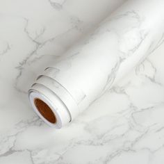 a roll of white wrapping paper on top of a marble counter with a brown spot in the middle