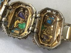 "Chunky unmarked 5 panel embossed prong set multi cabochon link bracelet. Nicely detailed, patterned, oval multicolored confetti, goldstone, green and purple cabochon, link bracelet. Secure fold over clasp. The links have medieval or possibly Renaissance look about them. Great vintage condition. Purple, green, turquoise, or blue and a hint of red on each corresponding, old gold link. Selro collectors would love this bracelet. Substantial and wonderful. This piece is much more impressive in perso Green Aurora Borealis, Tiger Ring, Gold Link, Red Blue Green, Colourful Necklace, Lariat Necklace, Green Turquoise, Purple Green, Fold Over