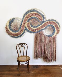 a chair sitting in front of a wall hanging