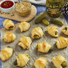 some food is laying out on a piece of tin foil with pickles and jalapenos in the background