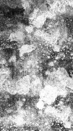 black and white photograph of the surface of an old concrete wall with cracks in it