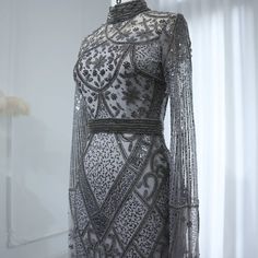 Experience elegance and sophistication with the Dreamy Vow Luxury Beaded Gray Muslim Evening Dress. Featuring intricate beading and a flattering flare silhouette, this dress is perfect for any formal occasion. The long sleeves add a touch of modesty, making it suitable for Muslim women. Elevate your style and make a statement at any wedding or party with this stunning gown. Elegant Gown With Rhinestones For Banquet, Elegant Rhinestone Gown For Banquets, Elegant Rhinestone Gown For Banquet, Elegant Evening Dress With Pearl Embroidery And Fitted Bodice, Rhinestone Evening Dress For Wedding, Elegant Fitted Gown With Pearl Embroidery, Elegant Floor-length Gown With Pearl Embroidery, Elegant Gala Gown With Pearl Embroidery, Elegant Embellished Gown For Banquet