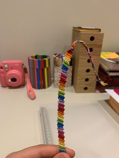 a hand holding a string that has been made out of beads and other crafting supplies