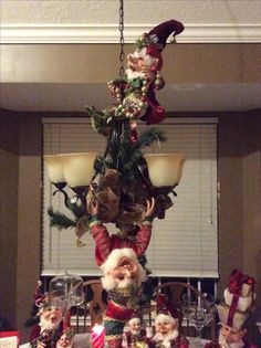 a chandelier decorated with santa claus and other christmas decorations