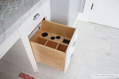 an open drawer in the middle of a kitchen counter top with drawers on each side