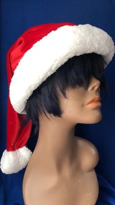 a mannequin head wearing a santa hat on top of a blue cloth background