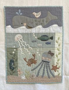 a close up of a piece of cloth with animals and fish on it in the water