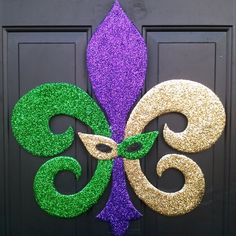 a purple and green mardi gras decoration on a door