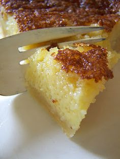 a piece of cake on a white plate with a knife and fork stuck in it