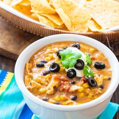 a white bowl filled with black beans and tortilla chips