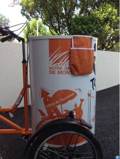 an orange bicycle parked next to a white cooler