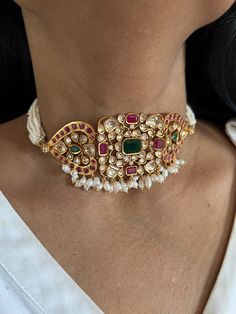 Simply a mark of royalty and elegance! You will definitely fall in love with the beautifully placed multicolored Kundan stones, One of our favorite picks for the wedding season. Do notice the beautiful pink beads in the pearl strings. Material: Copper Brass and silver mix, with gold plating Premium quality Choker Necklace Dimensions: Weight: 45 grams. Closure Type: Premium Adjustable Dori Earring Dimensions (Per Pair): Weight: 12 grams Length: 4.5 cm Width: 2 cm Closure Type: Push Back Closure with Extra Support Clip at the Back. Festive Pearl Necklace With Gemstone For Wedding, Pearl Gemstone Jewelry For Party, Gemstone Pearl Necklace For Wedding And Festivals, Pearl And Gemstone Necklace For Wedding And Festivals, Party Jewelry With Pearl And Gemstone, Party Pearl Gemstone Jewelry, Wedding And Festival Pearl Gemstone Necklace, Multicolor Pearl Drop Necklaces For Wedding, Wedding Pearl Necklace With Gemstone