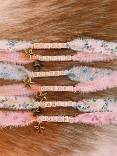 four hair clips with gold stars on them sitting next to some furry material that says golden