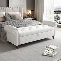 a white bed sitting on top of a carpeted floor next to a large window