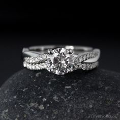 a close up view of a diamond ring on top of a rock