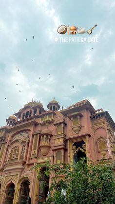 an old building with birds flying in the sky