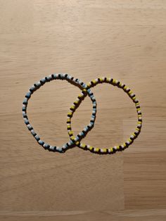 two bracelets sitting on top of a wooden table