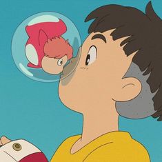 a boy is blowing bubbles in the air with his nose to an orange fish that's floating on top of him