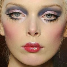 a close up of a woman with makeup on her face and eyeliners painted purple